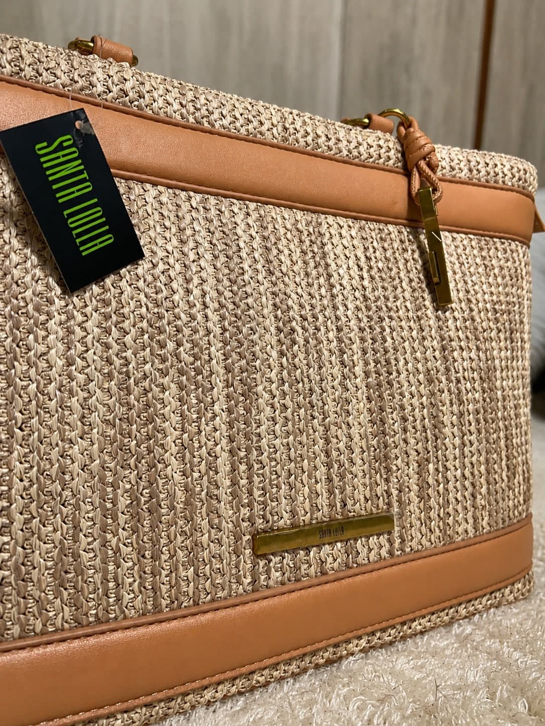 Bolsa Santa Lolla em palha — detalhe da etiqueta e ferragem dourada